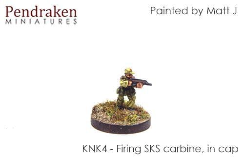 Standing, firing SKS carbine, in cap